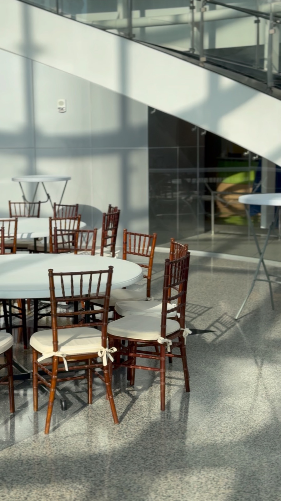 Event tables and Chiavari chairs arranged at a modern corporate venue