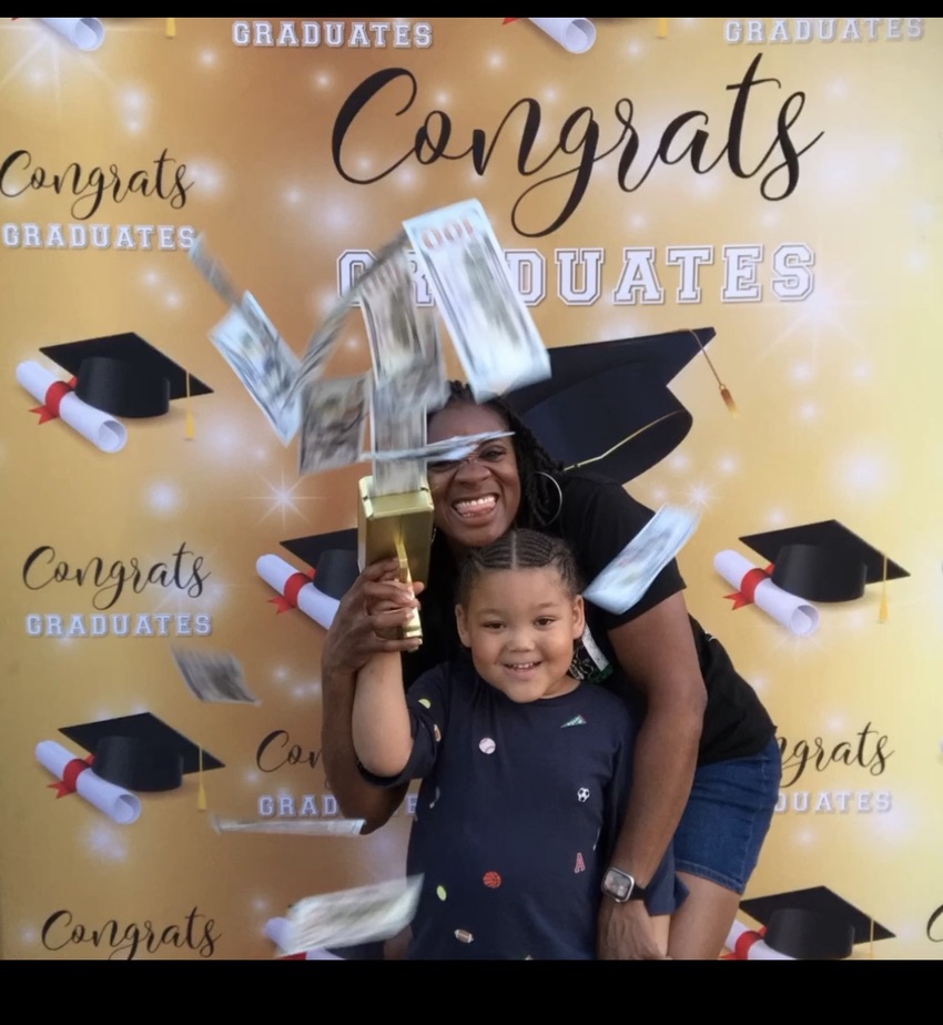 Guests posing in front of a gold celebration backdrop in Hampton Roads