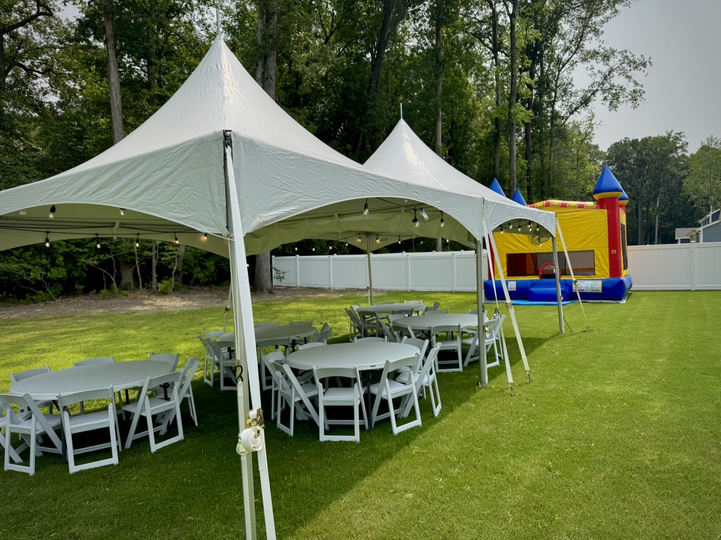 Party tents, tables, and a bounce house ready for an outdoor community event
